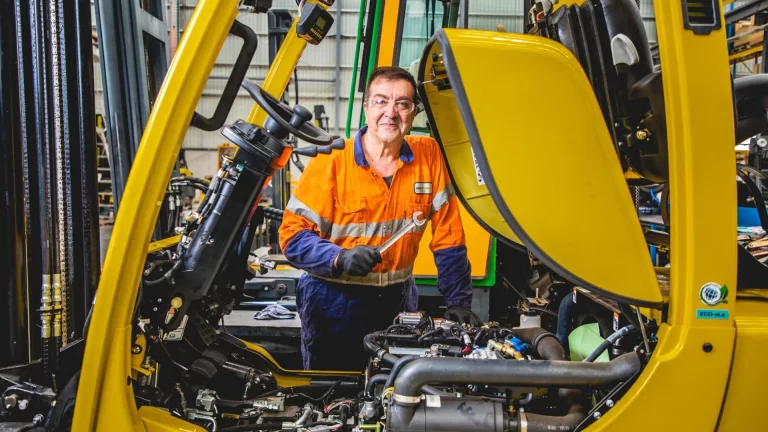 An Adaptalift mechanic servicing a forklift