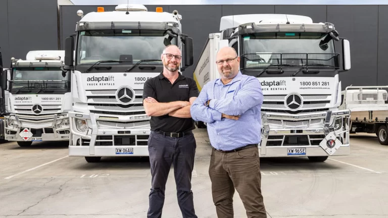 Adaptalift managers standing in front of a fleet of Adaptalift trucks