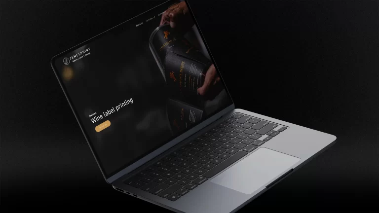 A preview of the Jamesprint website on a laptop screen in front of a dark background