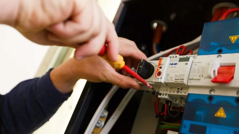 Content creation by Admedia: a close-up photograph of a Lee & Golding electrician wiring an electrical panel, demonstrating technical expertise.