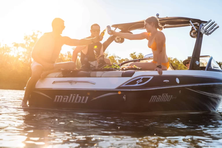 Admedia content creation: a group of friends toasting drinks on a Malibu ski boat during sunset, capturing the social atmosphere of Mildura Ski Club.