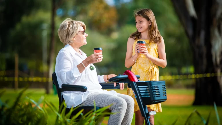 Lifestyle content creation by Admedia: a woman on a K Care mobility scooter enjoying an outing with a young girl, emphasizing independence and quality of life.